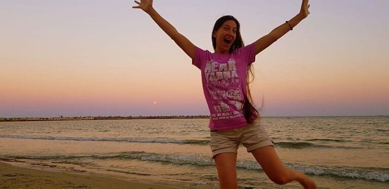 young woman jumping happily in front of the sea